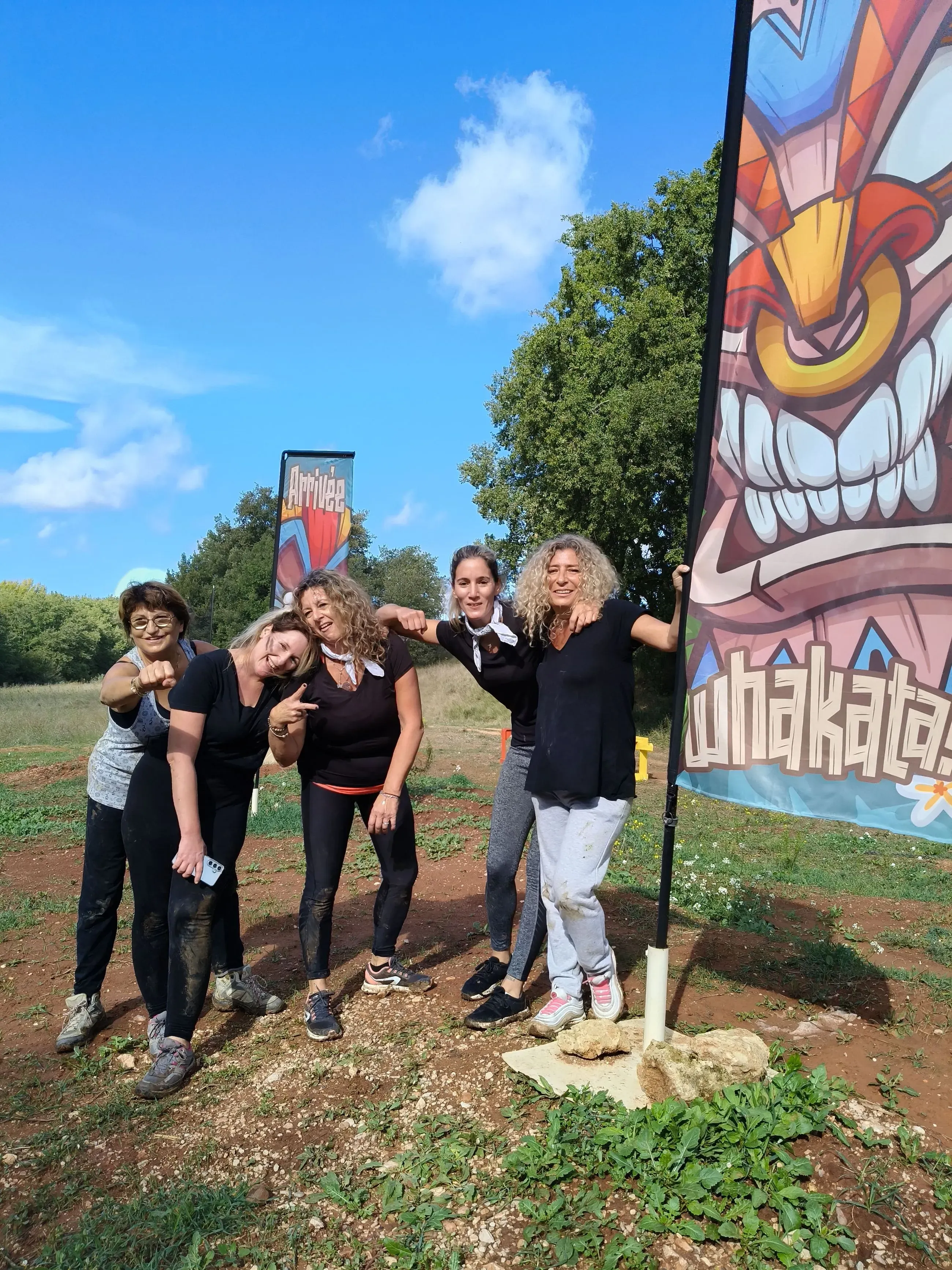 Une équipe en bandanas devant la banderole Whakata pendant un team building